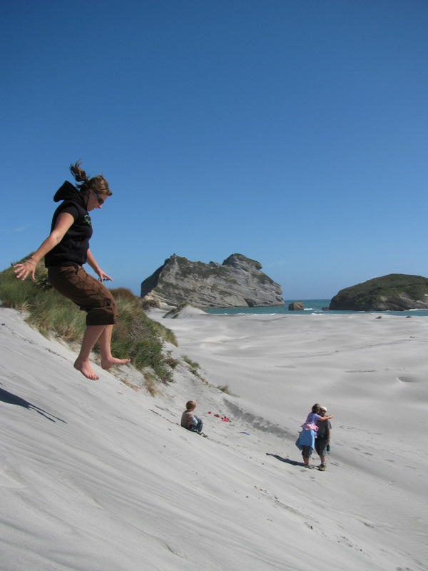 Emily leaping off a sand dune